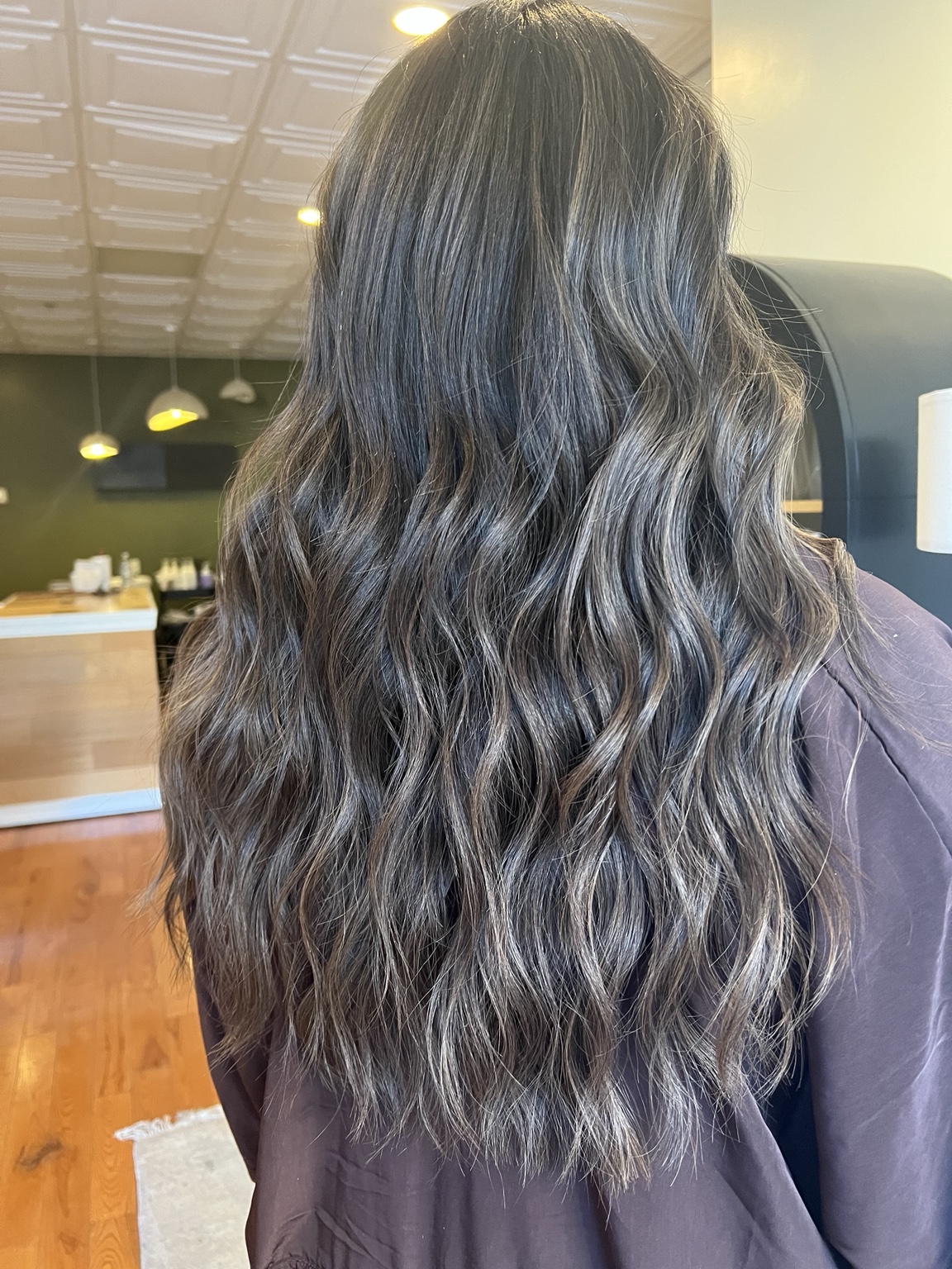 Glossy deep brunette color styled in long waves